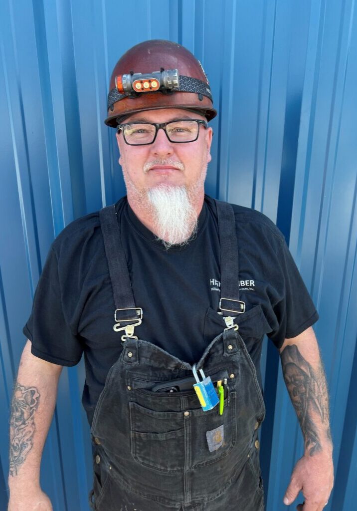 Bearded construction worker in hard hat and overalls